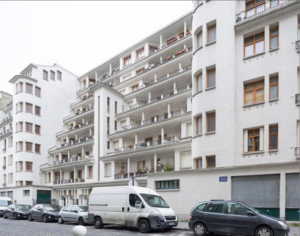 Picture is a white apartment building in Paris from the street