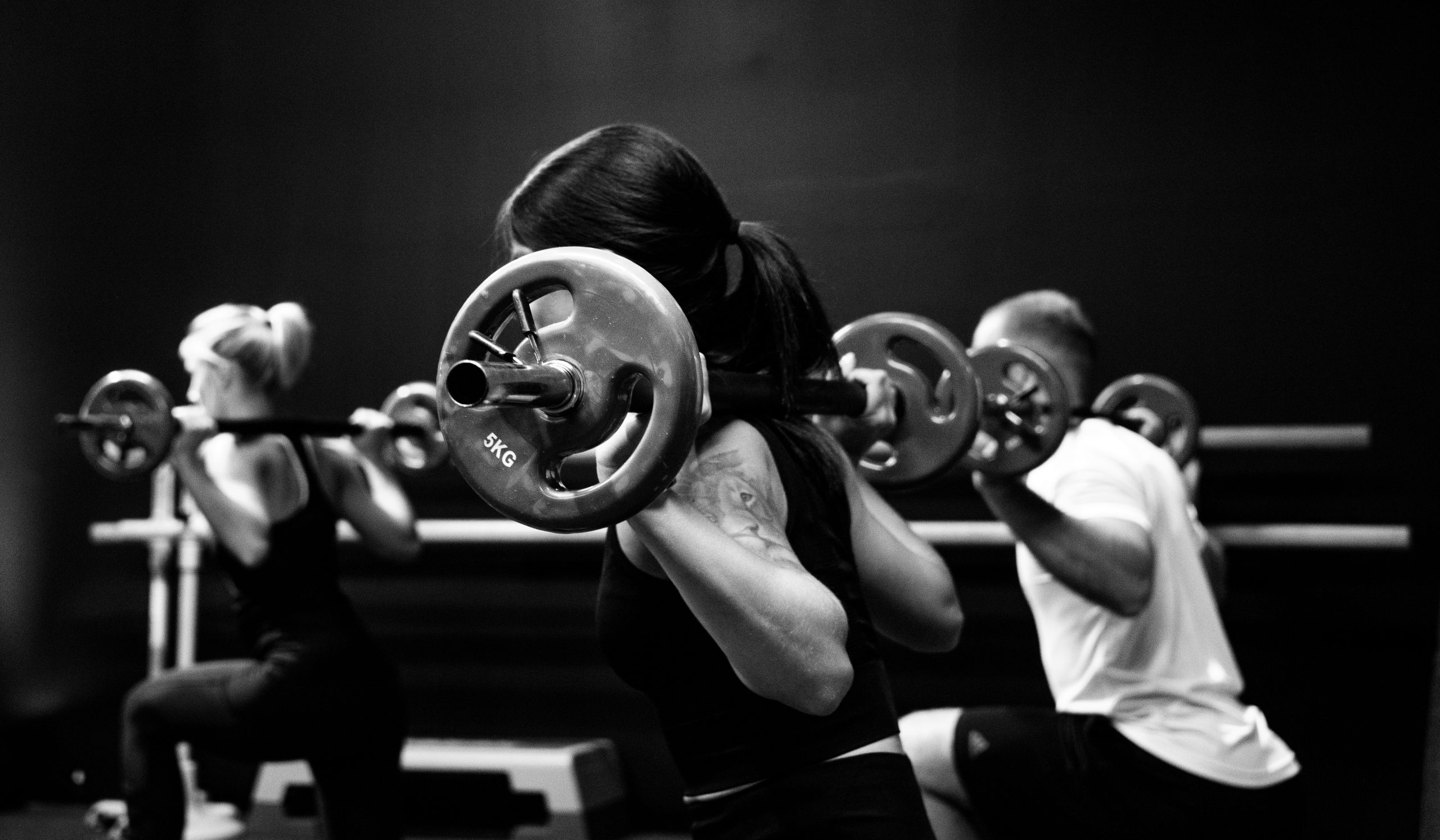 three people lifting barbells