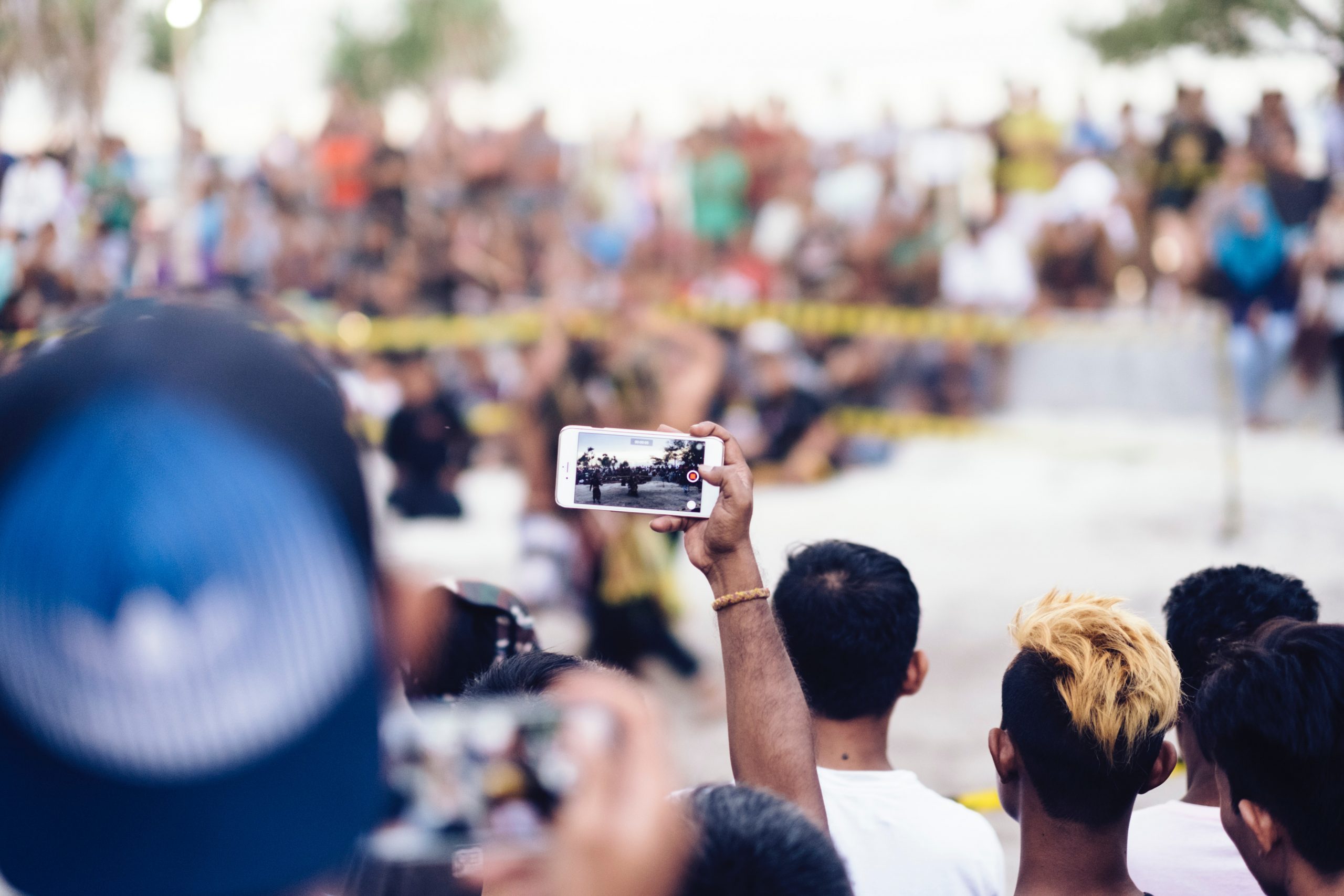 a person video taping an event with a smart phone