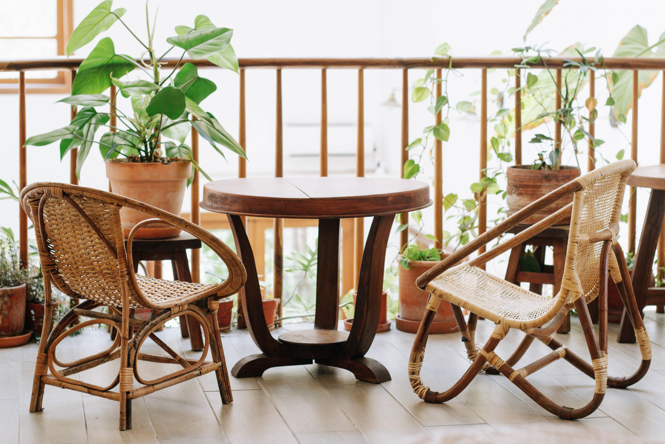 a balcony with a table, two chairs, and some plants