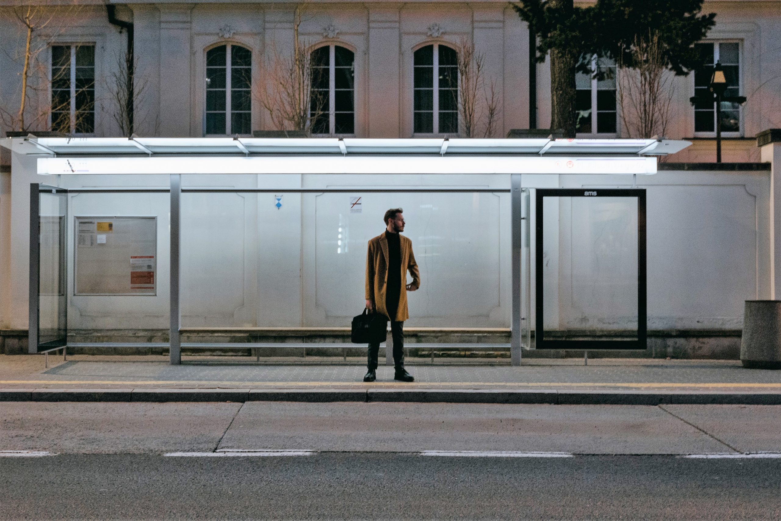 a man waiting at a bus stop