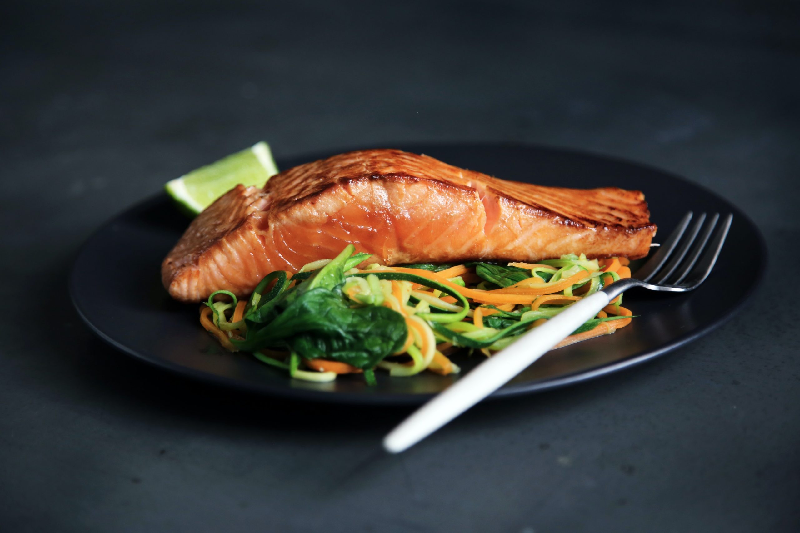 a plate of salmon fillet with vegetables