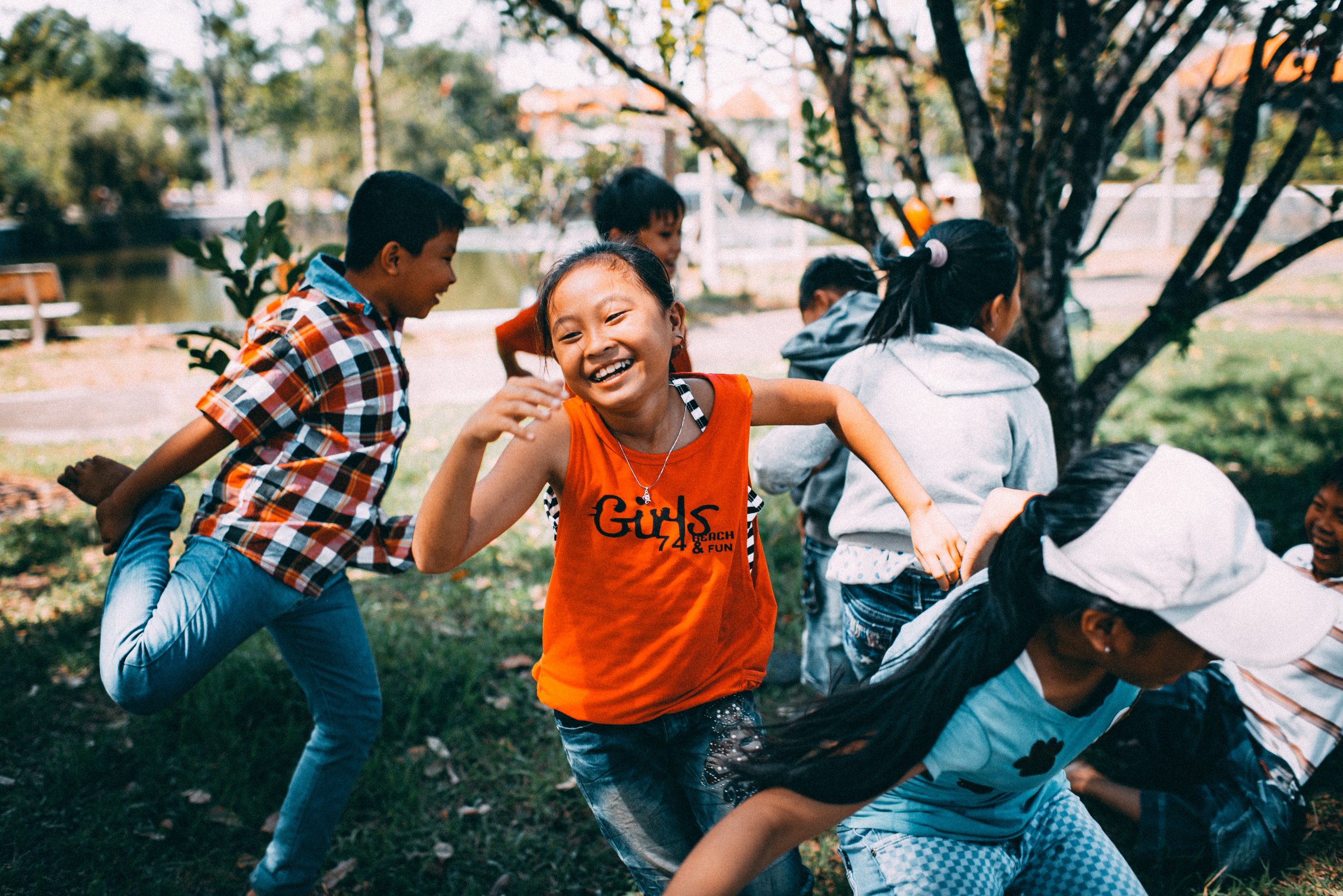 a group of children laughing and running outdoors