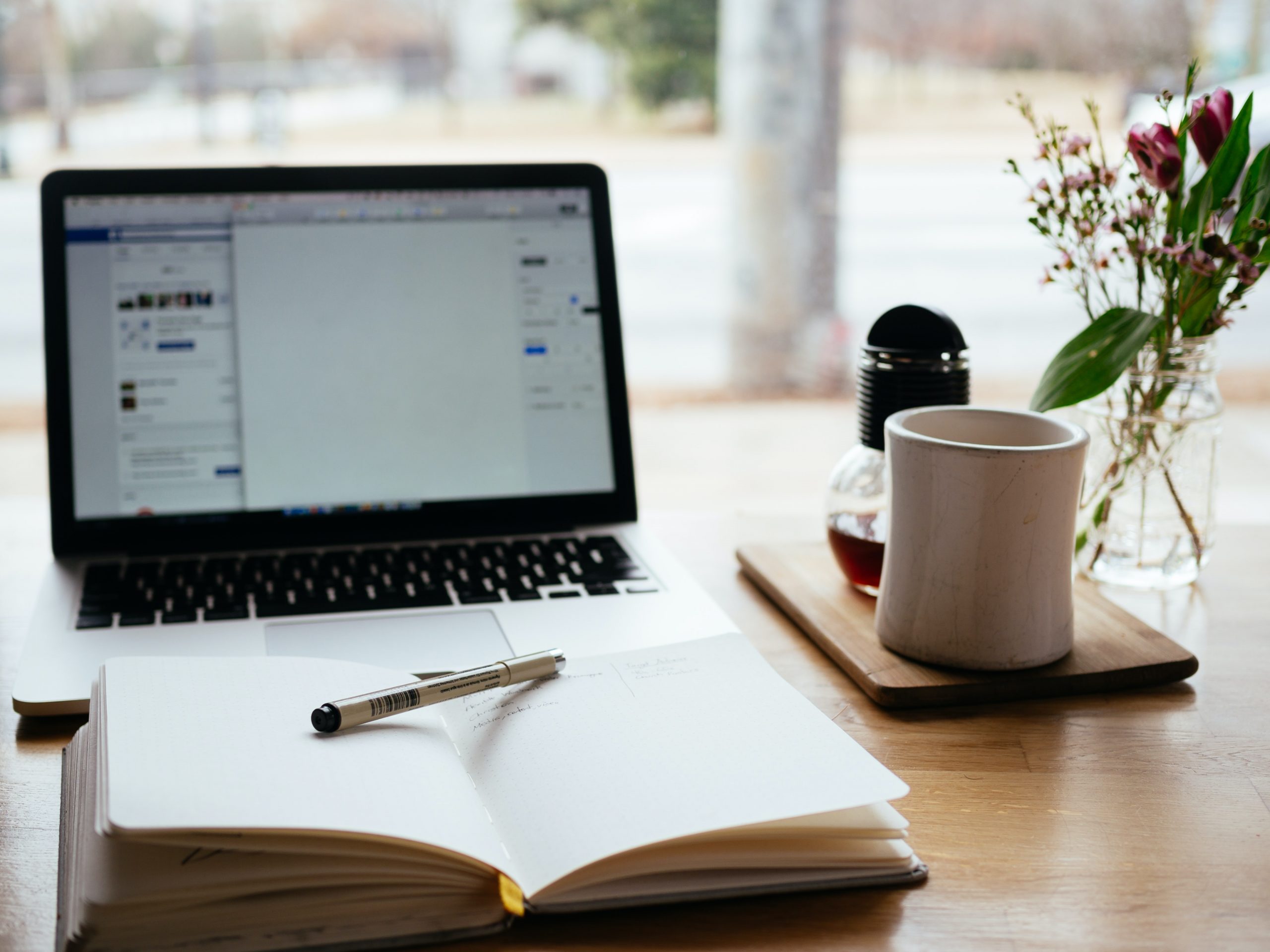 a MacBook, a notebook, etc. on a desk