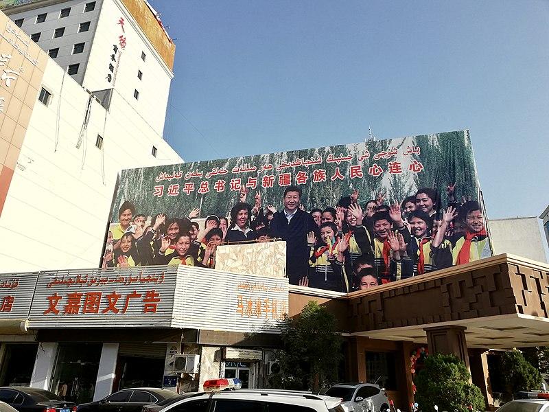 image of propagandist billboard in China showing President Xi Jingping surrounded by Uighur children.