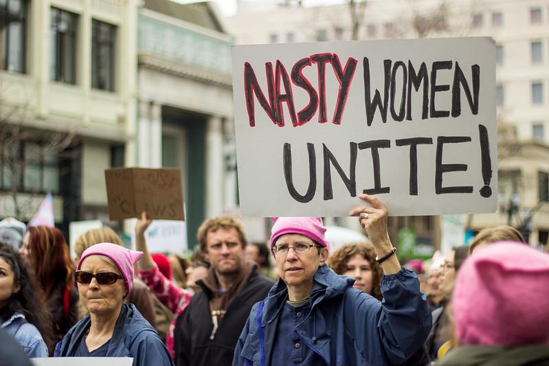 image of a protest with person holding a sign reading, "Nasty Women Unite!"