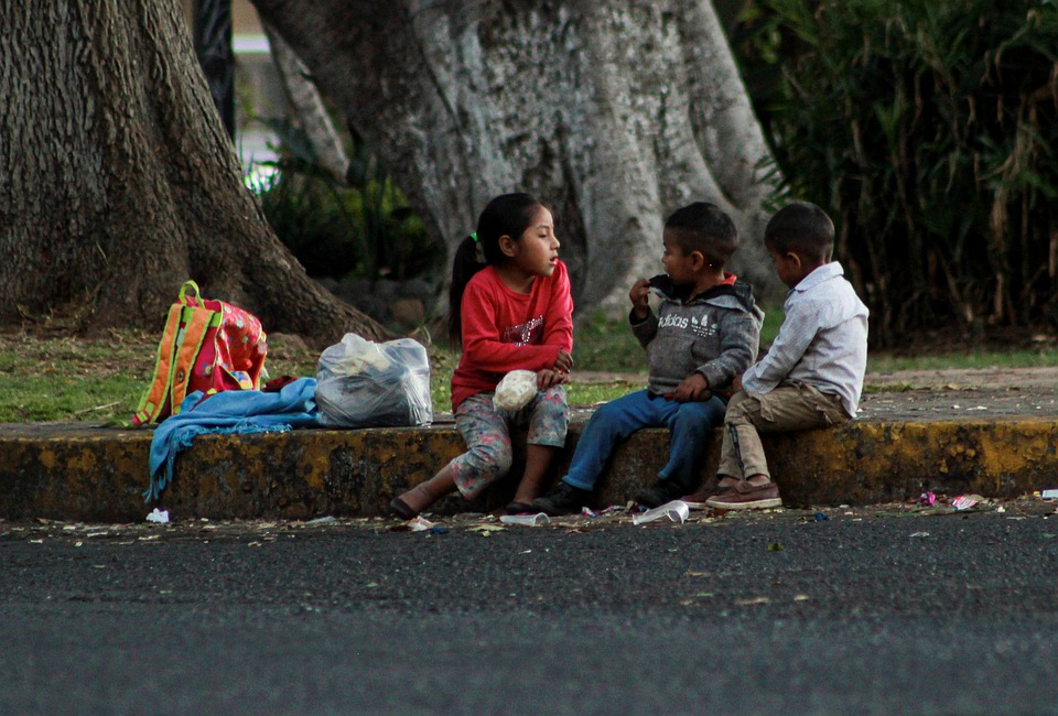 image of three children sitting on a curb